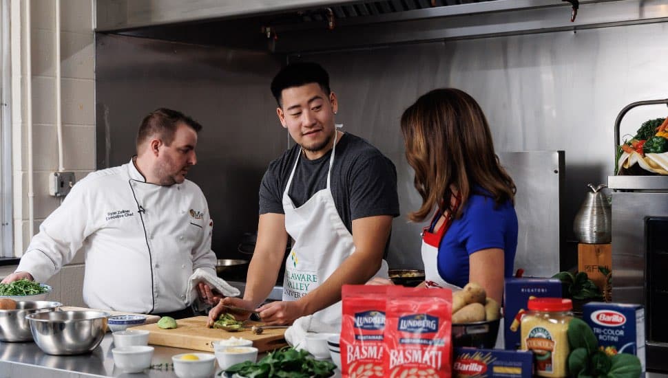 A student cooking in a kitchen for television