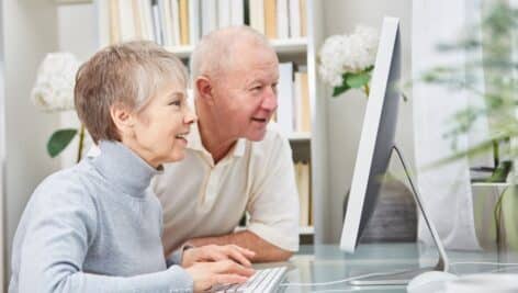 Two seniors looking at a computer screen.