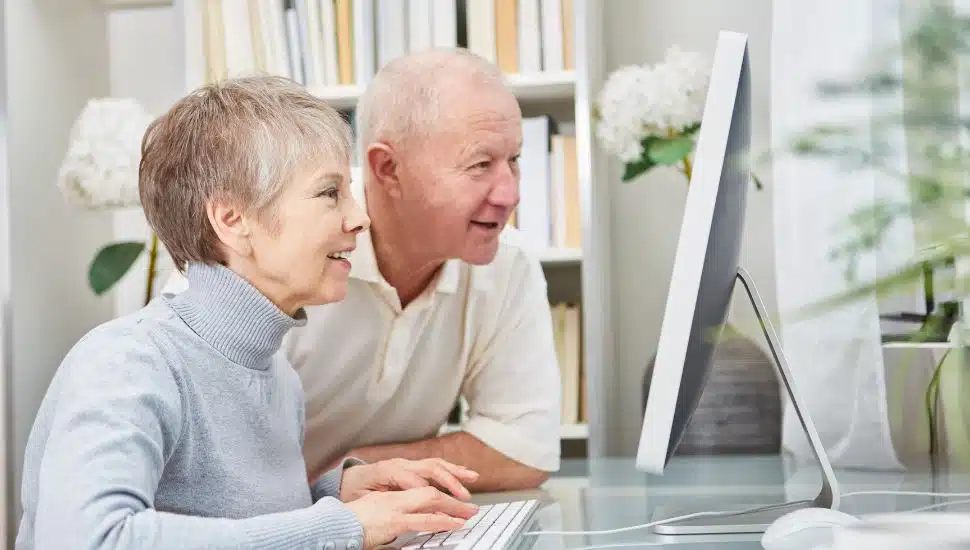Two seniors looking at a computer screen.