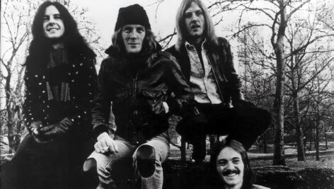 Four members of Humble Pie sitting outside.