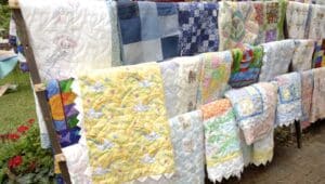 beautiful quilts hanging on racks.