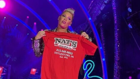The singer Pink holding a red shit that advertises Nat's Pizzeria.
