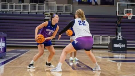maggie pina playing basketball on court with other player at northwestern university.