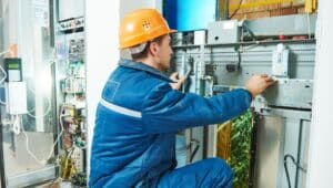 electrician worker adjusting equipment in elevator lift