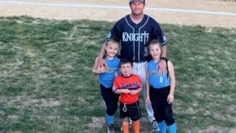 Patrick Brett, coaching at Community Night for North Penn, stands with his kids on the field before the game.