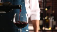 Bartender pouring wine into glass.