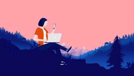 Person with computer and phone working in nature landscape, with forest and mountains in background. Remote work and freedom concept.