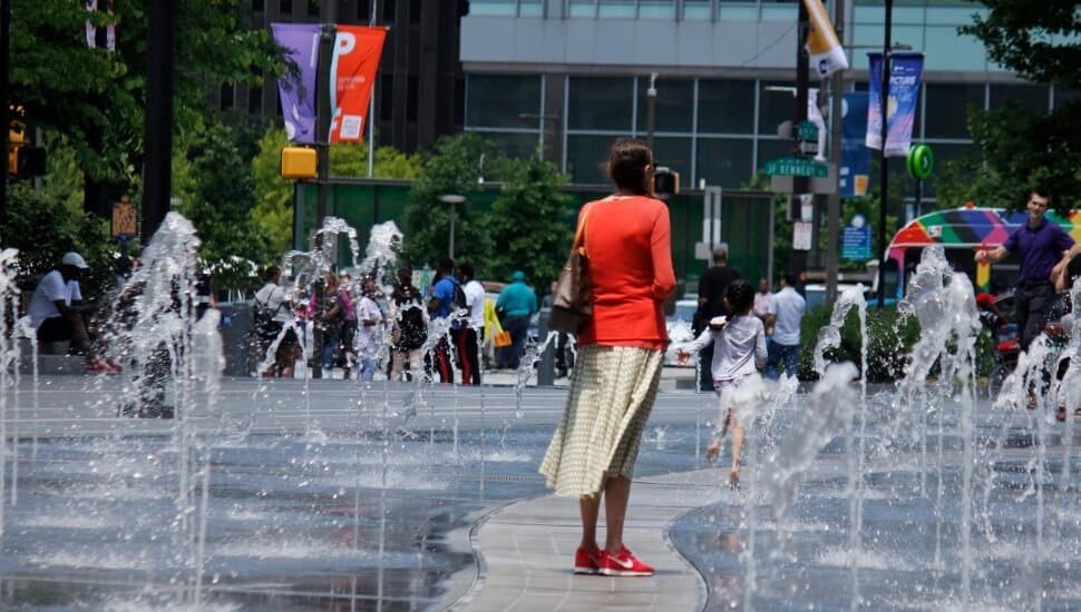 A woman watching her child play at Dilworth Plaza.