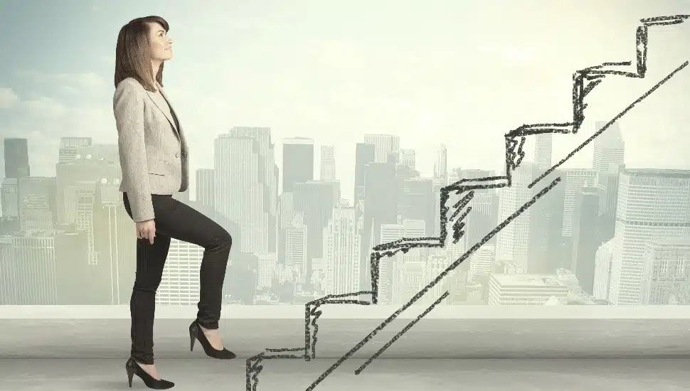 Business woman climbing up on hand drawn staircase concept on city background