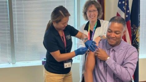Montgomery County Commissioners Chairman Ken Lawrence recieves a flu vaccine from a nurse with her supervisor