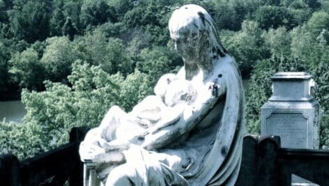One of the graves in Laurel Hill Cemetery is marked by a statue of woman holding two infants looking out over the Schuylkill River.