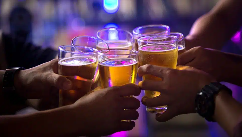 group of friends cheering together with beer