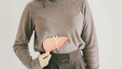 A person holding a liver-shaped cutout.