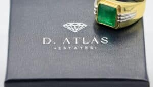 An emerald ring sitting on a D. Atlas box.