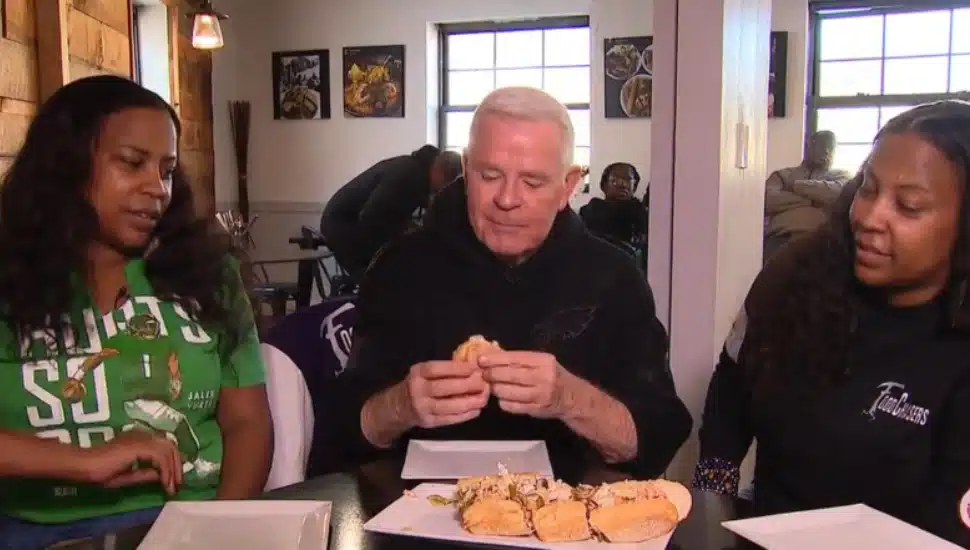 Maya and Kala Johnstone, owners of FoodChasers Kitchen, help Fox 29's Mike Jerrick make his own cheesesteak.