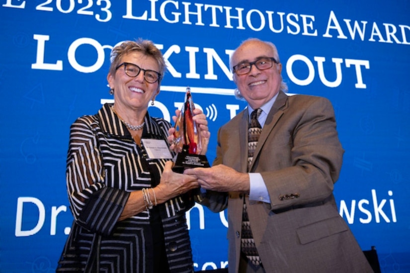 Susan Oleszewski receiving the Lighthouse Award from Dr. Anthony Di Stefano.