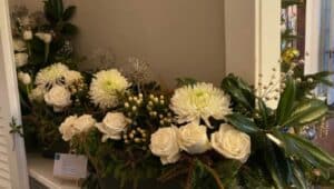 A lush magnolia swag, punctuated with white roses, mums and hybernium berries, was a highlight on the stair and buffet.