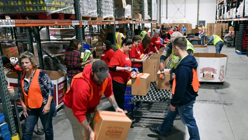 Giant employees and other volunteers pack food boxes at Helping Harvest, 117 Morgan Drive, Spring Township.