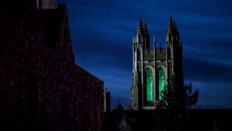 A green light is emanating from the tower at Saint Joseph's.