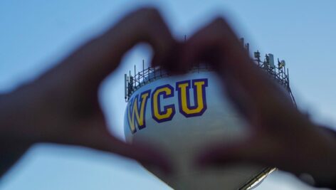 person making heart with hands around WCU