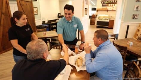 Ambler Savings Bank CEO Roger Zacharia in the bank's television ad with employees and customers of Penna's Italian Market, a new deli in Springhouse opened with a loan from the bank.