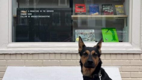 he couple's pup, Coffee, sits in front of the window of the Bookstore Bakery.