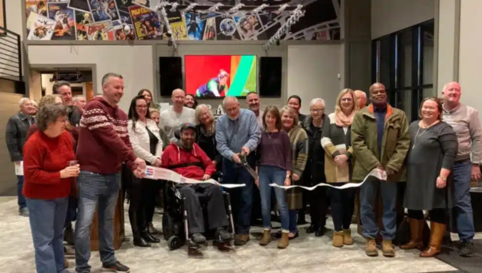 Broad Theater co-owner Charlie Crown cuts the ribbon at the grand opening ceremony of Cinema Brewery.