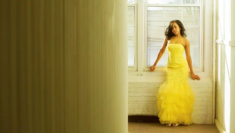 Girl in a window wearing a prom dress
