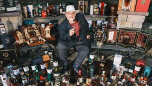Mikey Daley with his collection of whiskey.