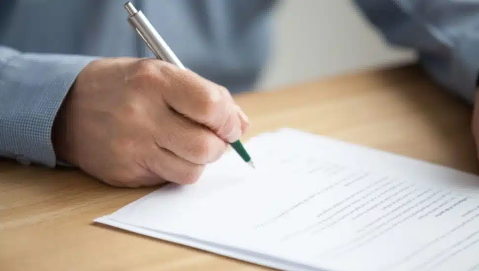 A person filling out a form.
