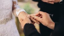 Groom giving bride the ring.