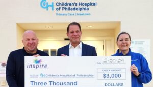 three people holding giant check at Children's Hospital of Philadelphia
