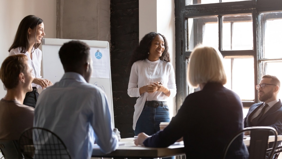 Young black woman speaking to her team in a conference room