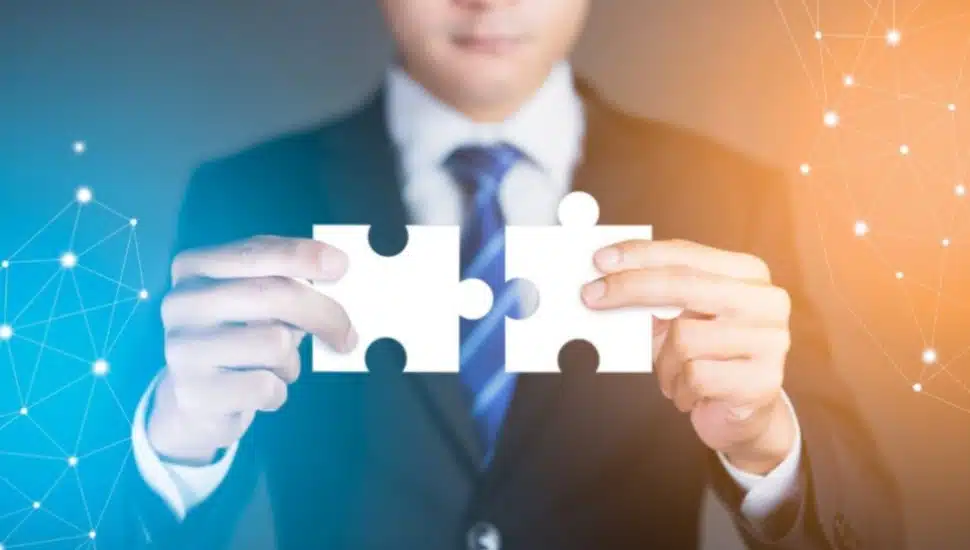 A man holding two puzzle pieces.