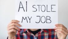 Man hold a sign saying AI stole his job.