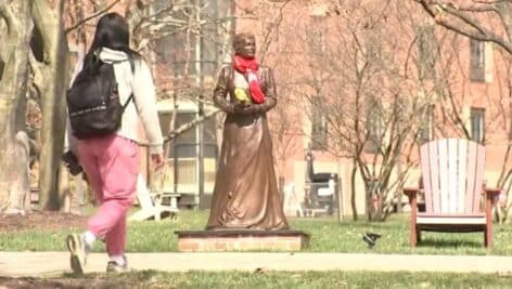 A student walks past the statue of Catherine McAuley, founder of the Sisters of Mercy.