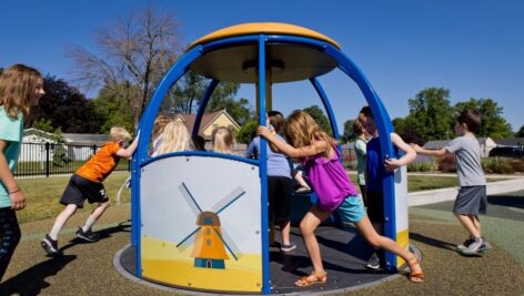 Children playing on a playground spinner.
