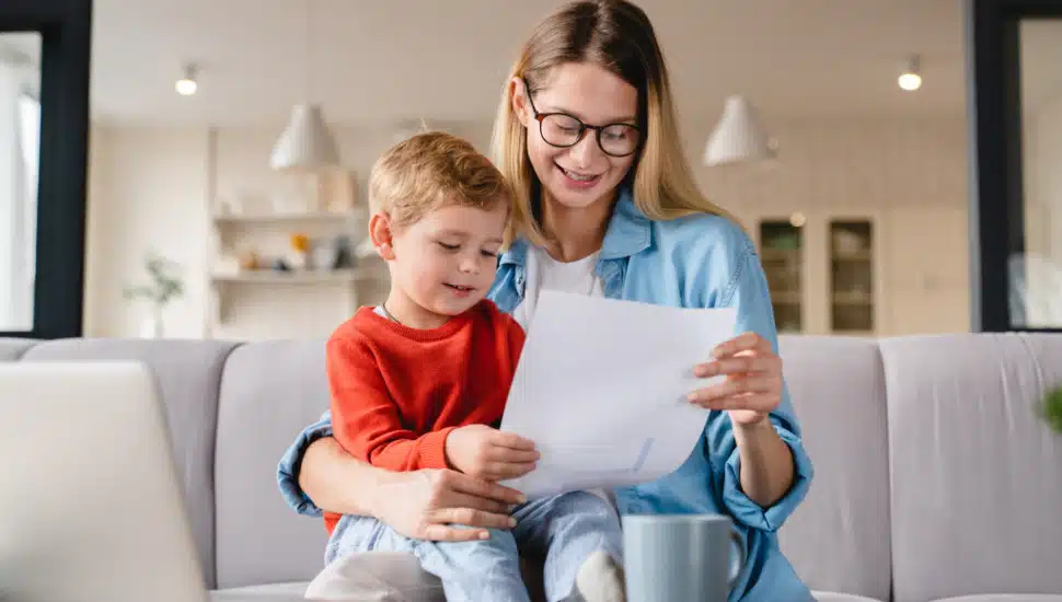 Mom sits on couch with child on her lap.