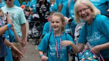 Arc of Chester County CEO Jeanne Meikrantz honors a young walker.at the May 19, 2024 Bubble Walk & Fun Day.