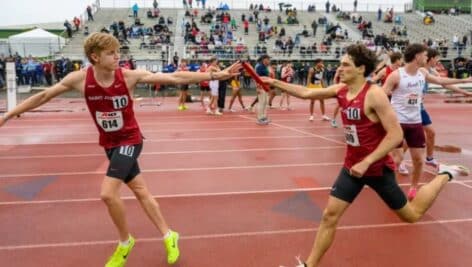 St. Joseph's University relay team member Graham Phillips hands off the baton to Josh Thaler at the Atlantic 10 championships.