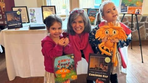 Plymouth Meeting author Lydia Cohn with two little girls holding two books based on Cohn's mother's poetry.