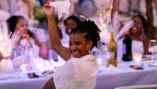 Woman at Fete en Blanc waving a white napkin over her shoulder.