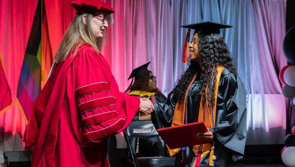 President Bastecki-Perez greets Elena Gehret, who composed and sang the Class of 2024’s class song, “Someday.”