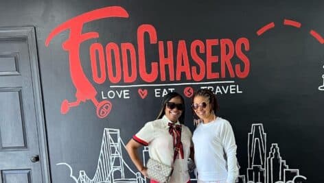 Dr. Kala and Dr. Maya Johnstone pose in front of FoodChasers' Kitchen