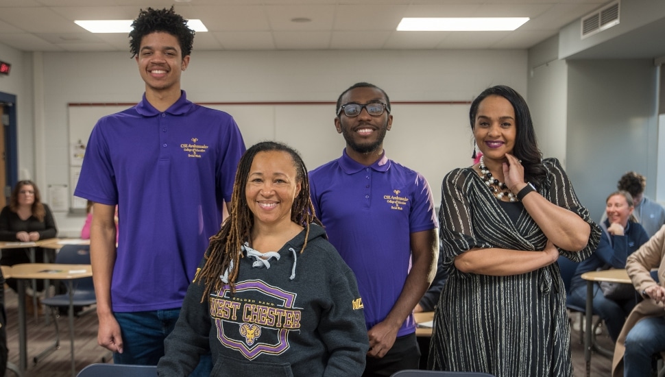 Dr. Desha Williams (center), dean of West Chester University’s College of Education and Social Work, is pictured at Plymouth Whitemarsh High School with recent WCU education graduates/former PRIZE Ambassadors Devin Davis (back row/left), Imere Williams (back row/middle), and Equity and Advancement Officer for Colonial School District Melissa Figueroa-Douglas (back row/right).