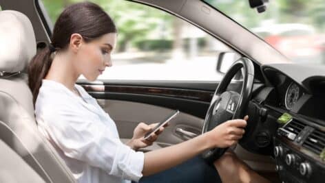 Young woman texting and driving