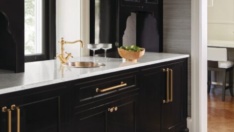 An improved butler's pantry at a 1915 Colonial home in Ardmore, now with shimmering black lacquer cbinets, mosaic floors and ceilings, snakeskin wallpaper and brass fixtures.