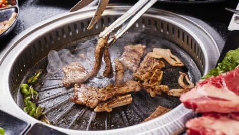 A hot grill in the center of a table lets customers cook their own meals.