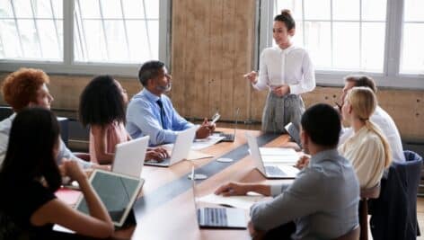 A female manager leads a sales team at a meeting.