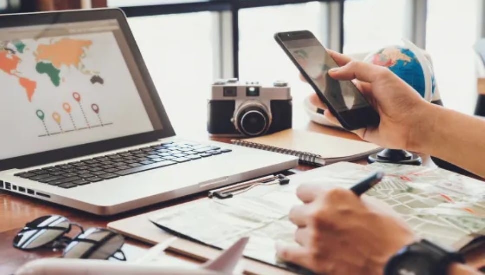 Person at a laptop planning vacation and evaluating financials.